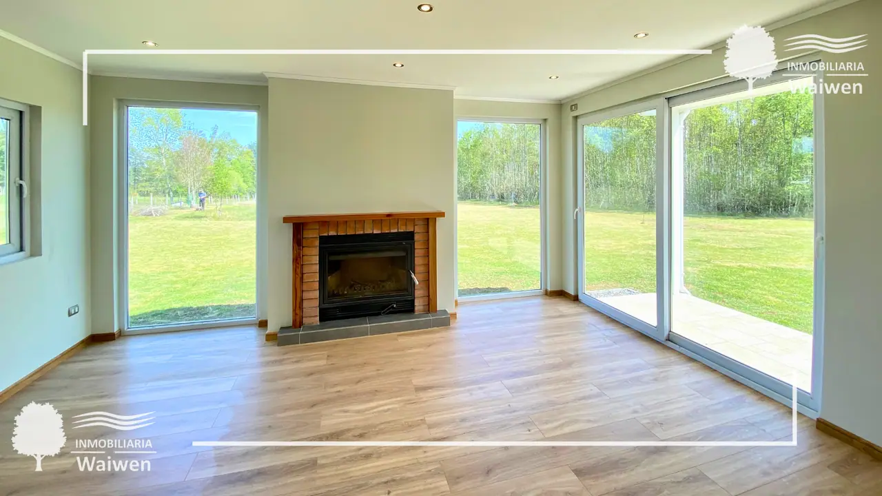 Interior de casa con chimenea y ventanales panorámicos